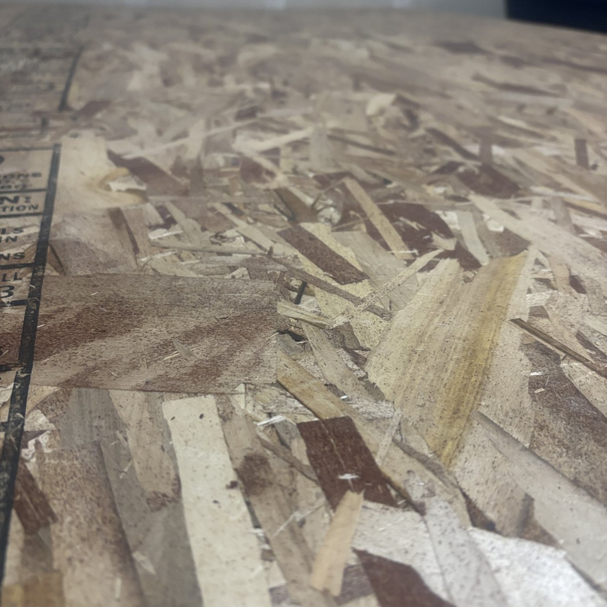 Angled view of OSB strand texture on 15/32 inch structural sheathing panel