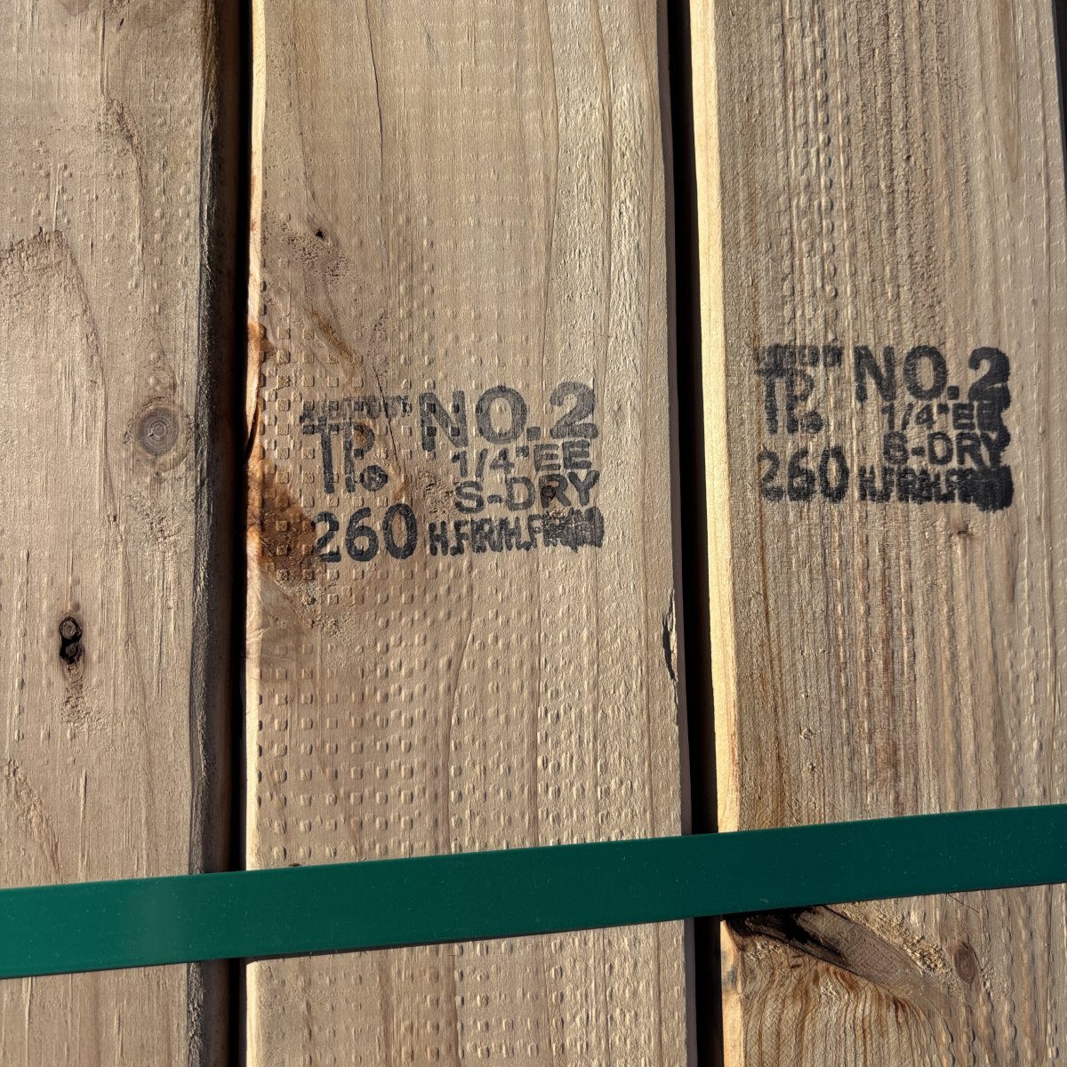Grade stamp on 2×4 #2 kiln-dried Hem-Fir lumber showing grade and mill identification