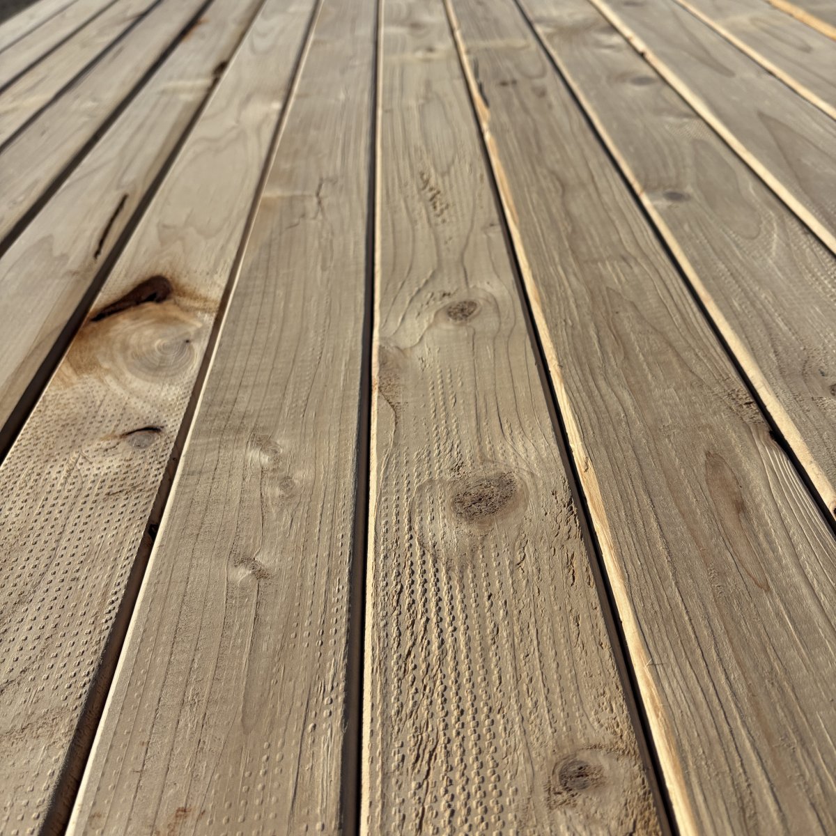 Close-up angled view of Hem-Fir wood grain on 2×4 #2 kiln-dried lumber showing natural texture and grain pattern