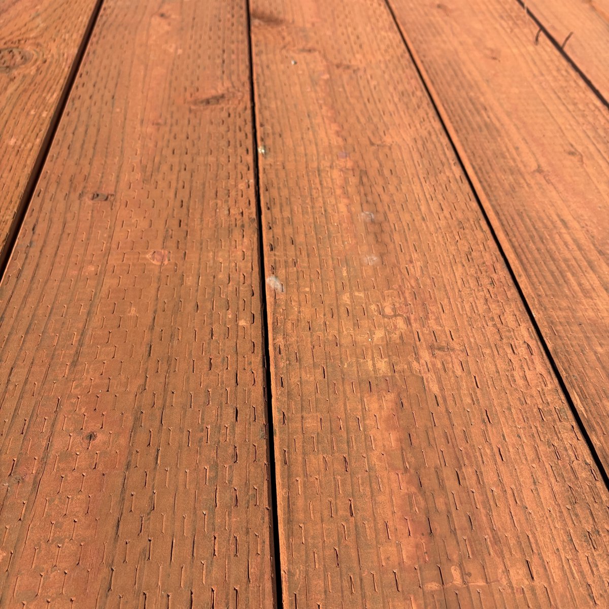 4x pressure-treated #2 fir lumber for ground contact, brown tone with incised surface at Dynamic Lumber Solutions yard