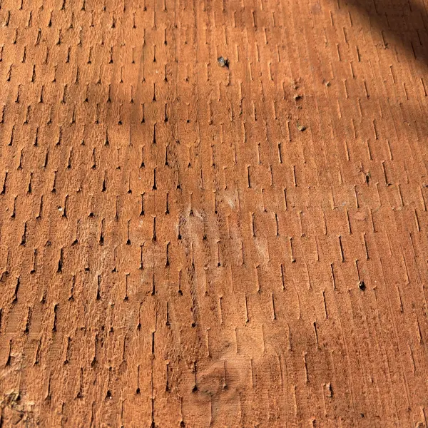 Close-up of incised surface on 2x ground contact pressure-treated #2 fir lumber (CAC treated)