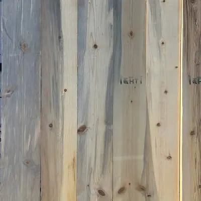 Macro close-up showing the natural wood grain, surface texture, and tight sound knots of a kiln-dried #4 grade whitewood board.